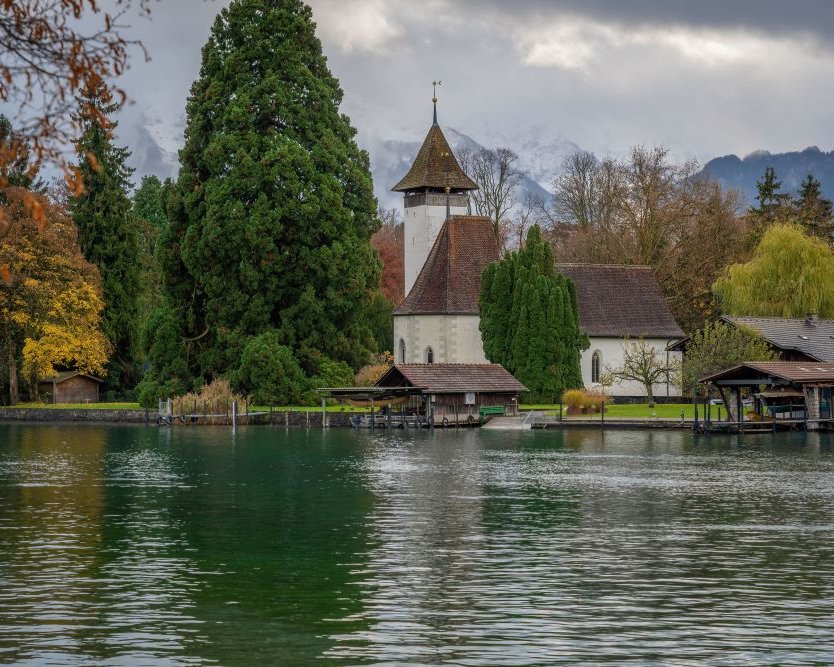 Kleine Kirche am Seeufer, umgeben von Bäumen – beliebter Ort für Trauungen am Wasser
