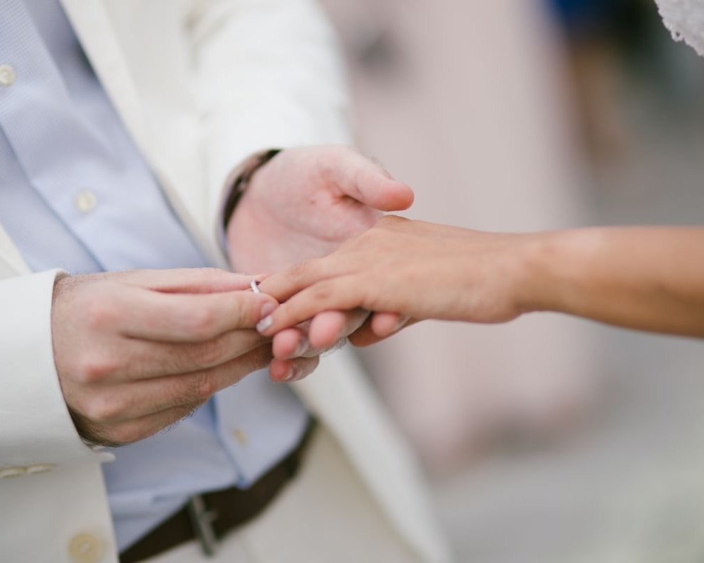 Der Bräutigam zieht der Braut während der Trauung feierlich den Ehering an